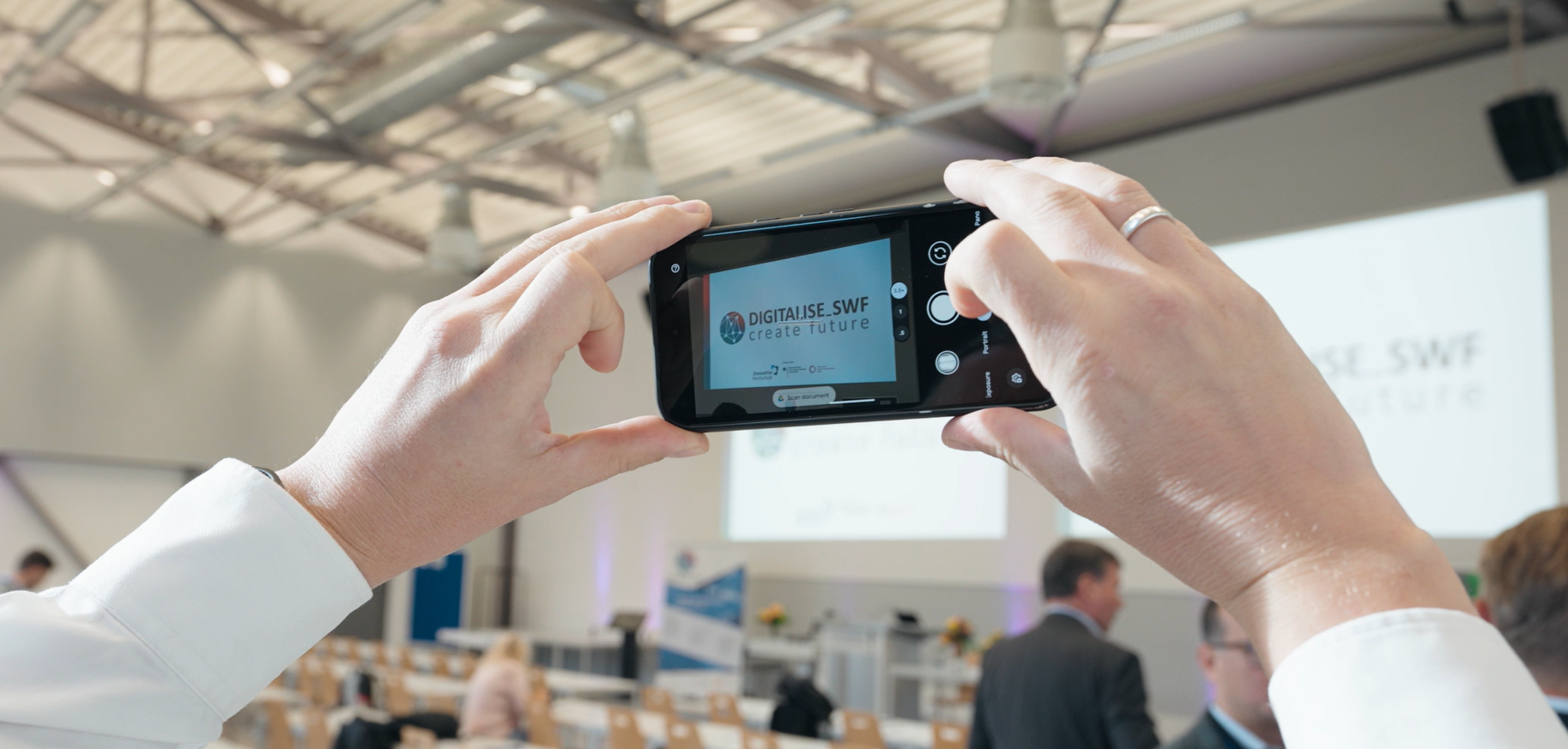 Ein Teilnehmer macht ein Foto am Transferkongress